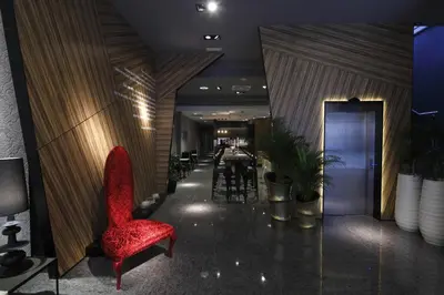 a lobby with a red chair and a dining room at Capitol Boutique Hotel in Santiago de Compostela