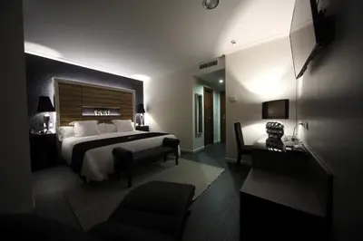 a hotel room with a large bed and a chair at Capitol Boutique Hotel in Santiago de Compostela