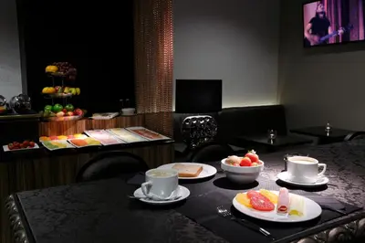 a table with cups and plates of fruit on it at Capitol Boutique Hotel in Santiago de Compostela