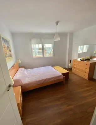 a bedroom with a bed and a dresser in it at PRAD in Foz