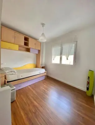 a large room with a bed and a wooden floor at PRAD in Foz