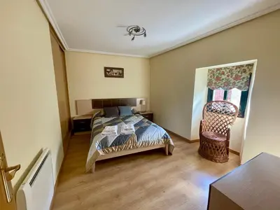 a bedroom with a bed and a chair in it at Casa rural Herminia in Ourense
