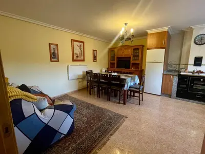 a living room and kitchen with a couch and a table at Casa rural Herminia in Ourense