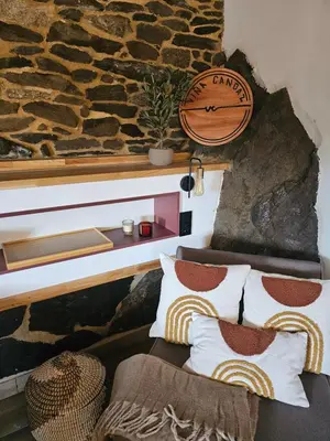 a room with a stone wall with a couch and a clock at Viña Candaz By Oktheway in Taboada