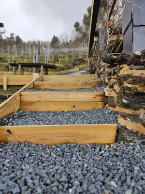 a set of wooden raised garden beds with rocks at Viña Candaz By Oktheway in Taboada