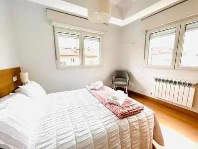 a bedroom with a large bed with two towels on it at Apartamento San José in Milladoiro