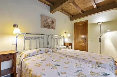 a bedroom with a bed and a desk and lamp at Apartamentos rurales Casa Xepo in Rengos