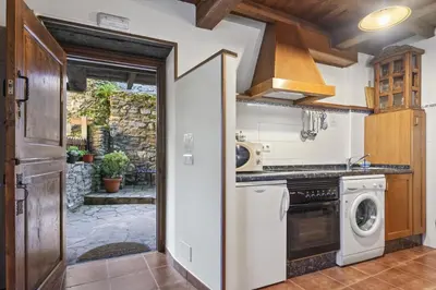 a kitchen with a washer and dryer at Apartamentos rurales Casa Xepo in Rengos