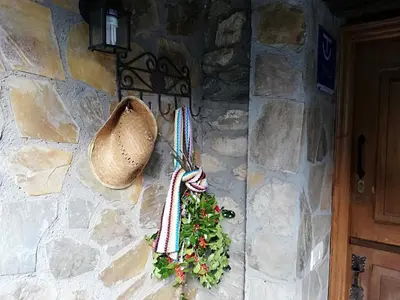 a stone wall with a wreath and a hat on it at Apartamentos rurales Casa Xepo in Rengos