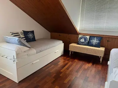 a bedroom with a white bed with blue pillows at El Pedregal - Playa de Miño in Miño