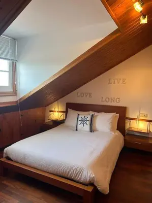 a bedroom with a large bed with love written on the wall at El Pedregal - Playa de Miño in Miño