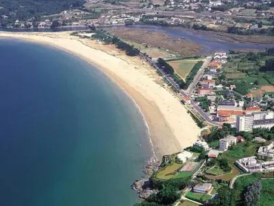 an aerial view of a beach next to the water at El Pedregal - Playa de Miño in Miño