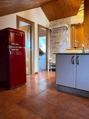 a kitchen with a red refrigerator and a tile floor at El Pedregal - Playa de Miño in Miño