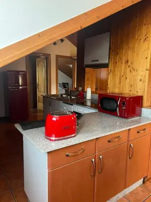 a kitchen with a red microwave on a counter at El Pedregal - Playa de Miño in Miño
