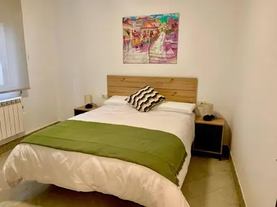 a bedroom with a bed with a green blanket at casa ribeiro in Ribadavia