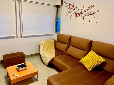 a living room with a brown couch and a table at casa ribeiro in Ribadavia