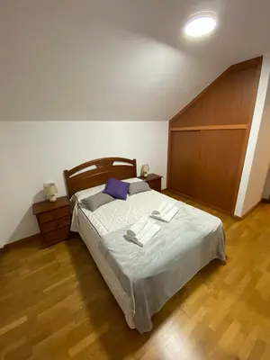 a bedroom with a bed with two towels on it at Casa do Aloumiño in Portomarin