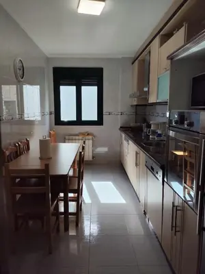 a kitchen with a table and a dining room at Casa do Aloumiño in Portomarin