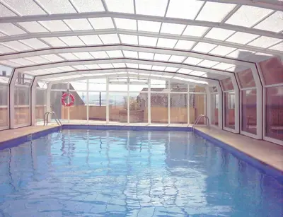 an indoor swimming pool with an open ceiling at EnFOZ Las Catedrales: Playa, Piscina y Parking in Foz