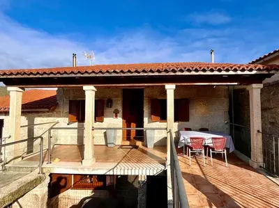 a patio of a house with a table and chairs at Casa María da Reza in Ribadavia
