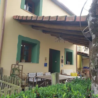an outdoor patio with a wooden table and chairs at Habitaciones - La Pumarada de Limés I in Cangas del Narcea