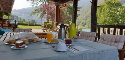 a table with a blue table cloth with food on it at Habitaciones - La Pumarada de Limés I in Cangas del Narcea