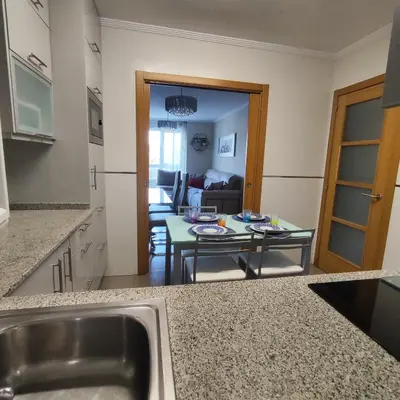 a kitchen with a sink and a living room at Piso céntrico en Viveiro con aparcamiento in Viveiro