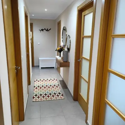 a hallway with a door and a rug on the floor at Piso céntrico en Viveiro con aparcamiento in Viveiro