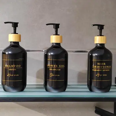 three bottles of soap sitting on a shelf at Piso céntrico en Viveiro con aparcamiento in Viveiro