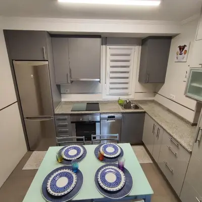 a kitchen with a table with plates on it at Piso céntrico en Viveiro con aparcamiento in Viveiro