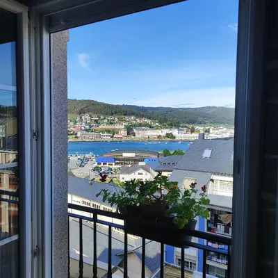 a window with a view of a city and a harbor at Piso céntrico en Viveiro con aparcamiento in Viveiro
