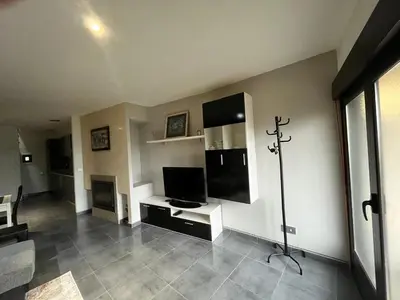 a living room with a flat screen tv and a tv stand at A MIÑA CASIÑA -TERMAS OURENSE in Ourense
