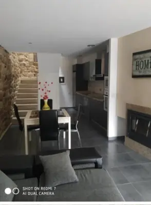 a living room with a dining table and a kitchen at A MIÑA CASIÑA -TERMAS OURENSE in Ourense