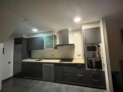 a kitchen with stainless steel appliances and gray cabinets at A MIÑA CASIÑA -TERMAS OURENSE in Ourense