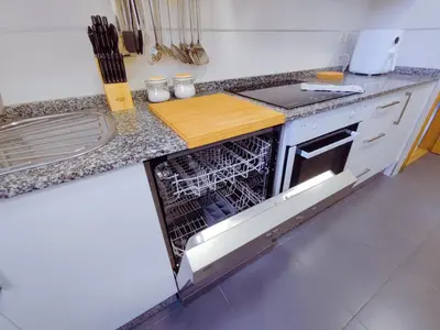 a kitchen with an open dishwasher in a counter at Vivienda Novo Betanzos in Betanzos