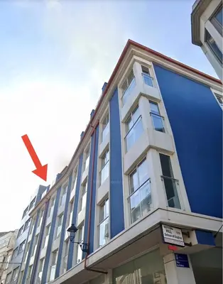 a blue building with a red arrow on it at Vivienda Novo Betanzos in Betanzos