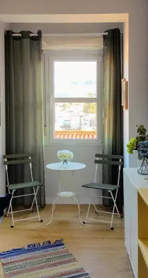 a table and two chairs in a room with a window at Apartamento Arcoiris in Betanzos