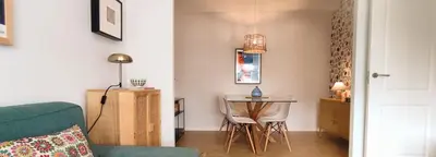 a living room with a table and a green couch at Apartamento Arcoiris in Betanzos
