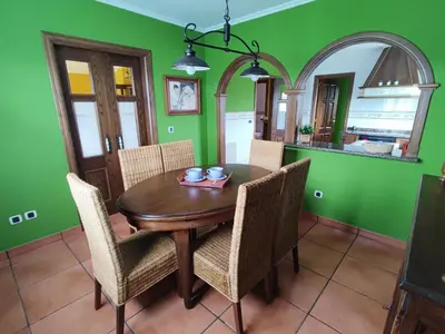 a dining room with a wooden table and chairs at Casa de campo en Ribadeo in Ribadeo