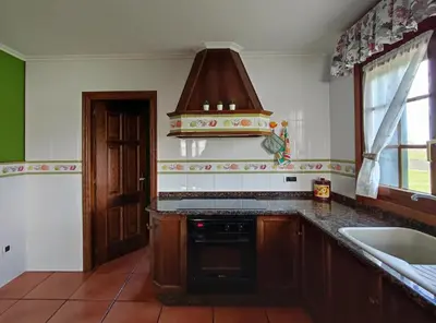 a kitchen with a sink and a stove top oven at Casa de campo en Ribadeo in Ribadeo