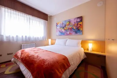a bedroom with a bed and a painting on the wall at Apartamento SpítiCasa in Santiago de Compostela