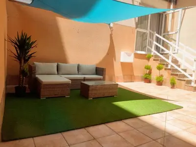 a patio with a couch and a green rug at Apartamento SpítiCasa in Santiago de Compostela