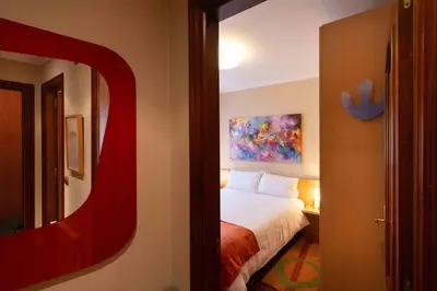 a hotel room with a bed and a mirror at Apartamento SpítiCasa in Santiago de Compostela