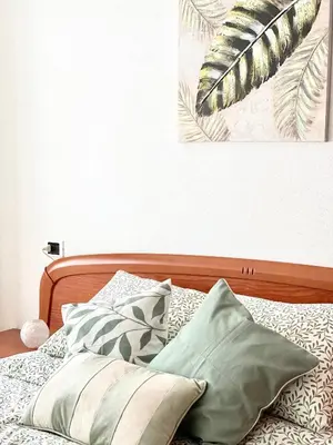 a bed with pillows and a painting on the wall at Apartamento Rivela in Burela de Cabo