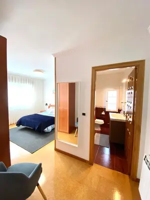 a bedroom with a bed and a bathroom with a mirror at Apartamento Rivela in Burela de Cabo