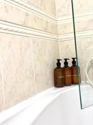 two bottles of soap sitting on the edge of a bath tub at Apartamento Rivela in Burela de Cabo