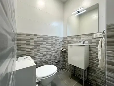 a bathroom with a toilet and a sink and a mirror at Romero AP in Santiago de Compostela