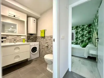 a bathroom with a sink and a toilet and a bed at Romero AP in Santiago de Compostela