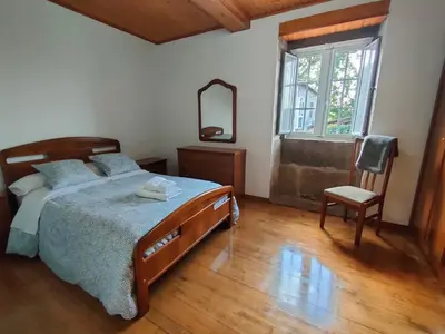 a bedroom with a bed and a mirror and a chair at Casa Telmo in Acova