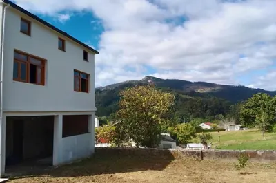 a white house with a mountain in the background at Casa Calvo in Vivero
